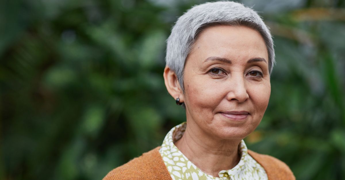 Older woman outside and looking at the camera