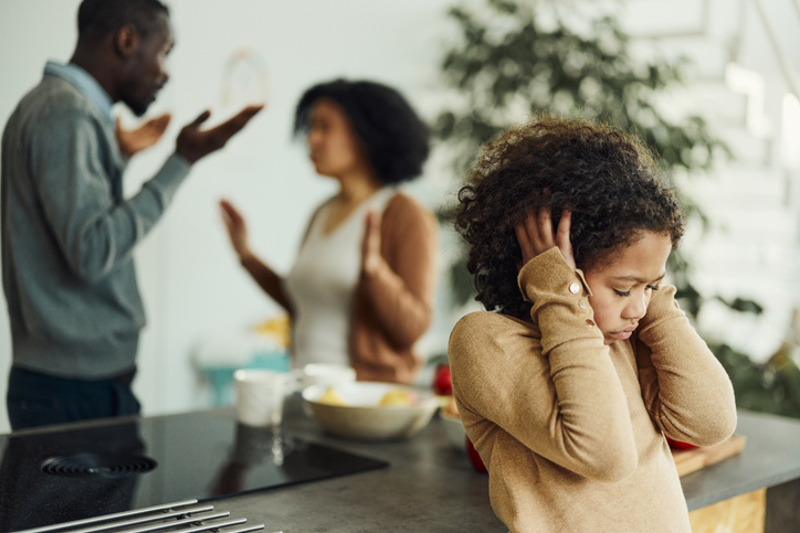 parents fighting behind stressed child
